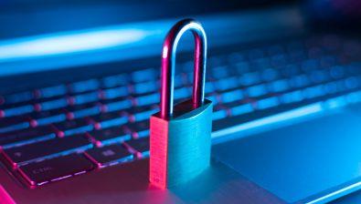 Un cadenas fermé est posé sur le clavier d'un ordinateur portable ouvert